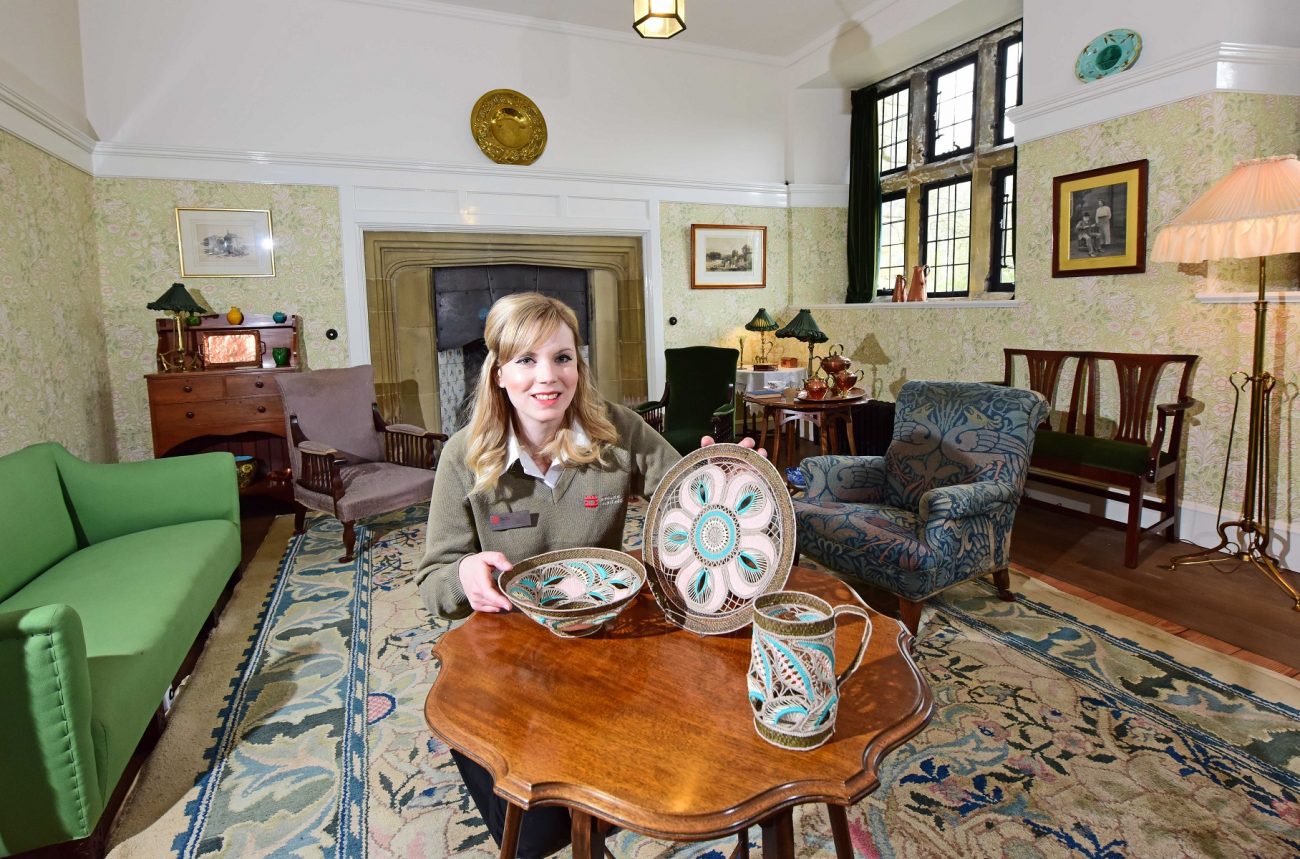 Victoria Conroy van English Heritage met werk van Pat Brunsdon in een in Arts and Crafts-stijl ingerichte kamer.