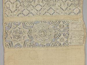 Detail van een pronkrol, in 1678 door Elizabeth Clowder gemaakt. Op deze pronkrol is zowel veelkleurig borduurwerk in zijde, witwerk en opengewerkt borduurwerk te vinden - 19 x 87 cm.