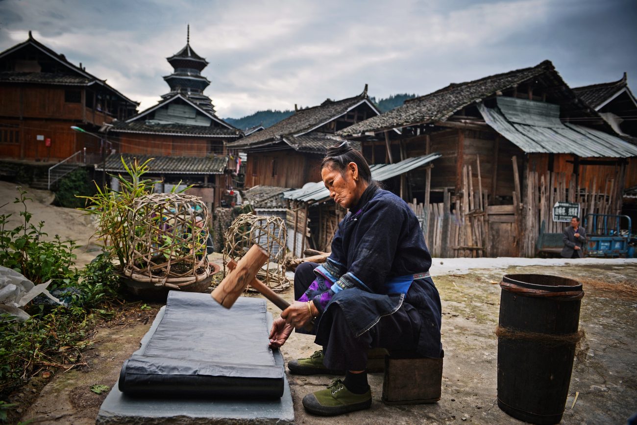 Een Dong-vrouw kalandert een doek, dat eerst met indigo is geverfd, Si Zhai, Liping Country - foto Wu Zeng Ou.
