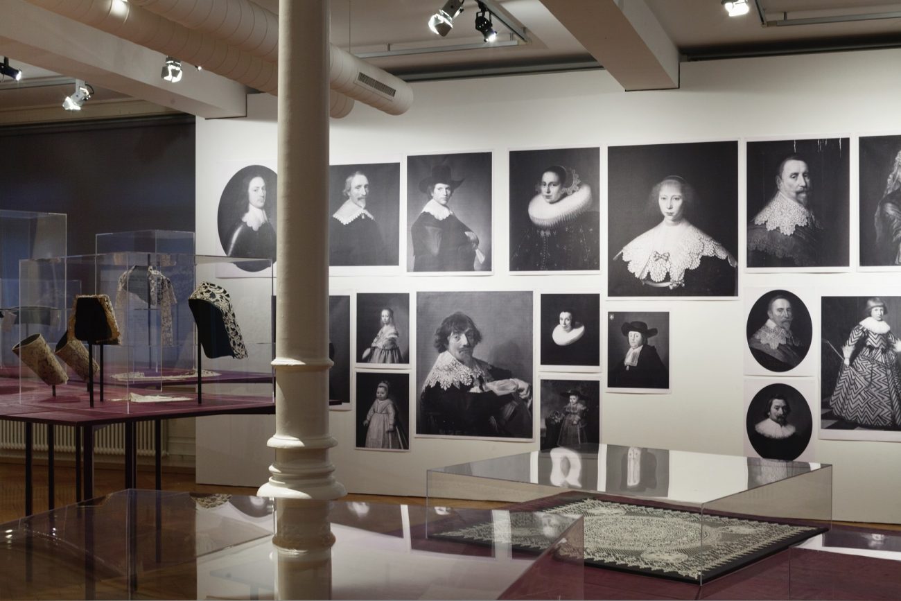 Overzichtsfoto van de tentoonstelling met afbeeldingen van kant op schilderijen - foto Susanne Stauss.